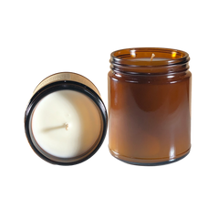 a glass jar with a candle inside of it